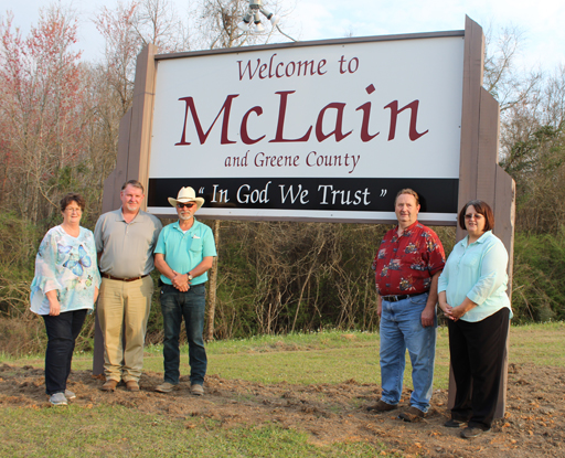 Members of McLain Community with SRE Sand Hill District manager by town sign that was funded by NHN Grant.
