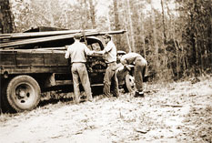 Linemen standing by truck in the early years