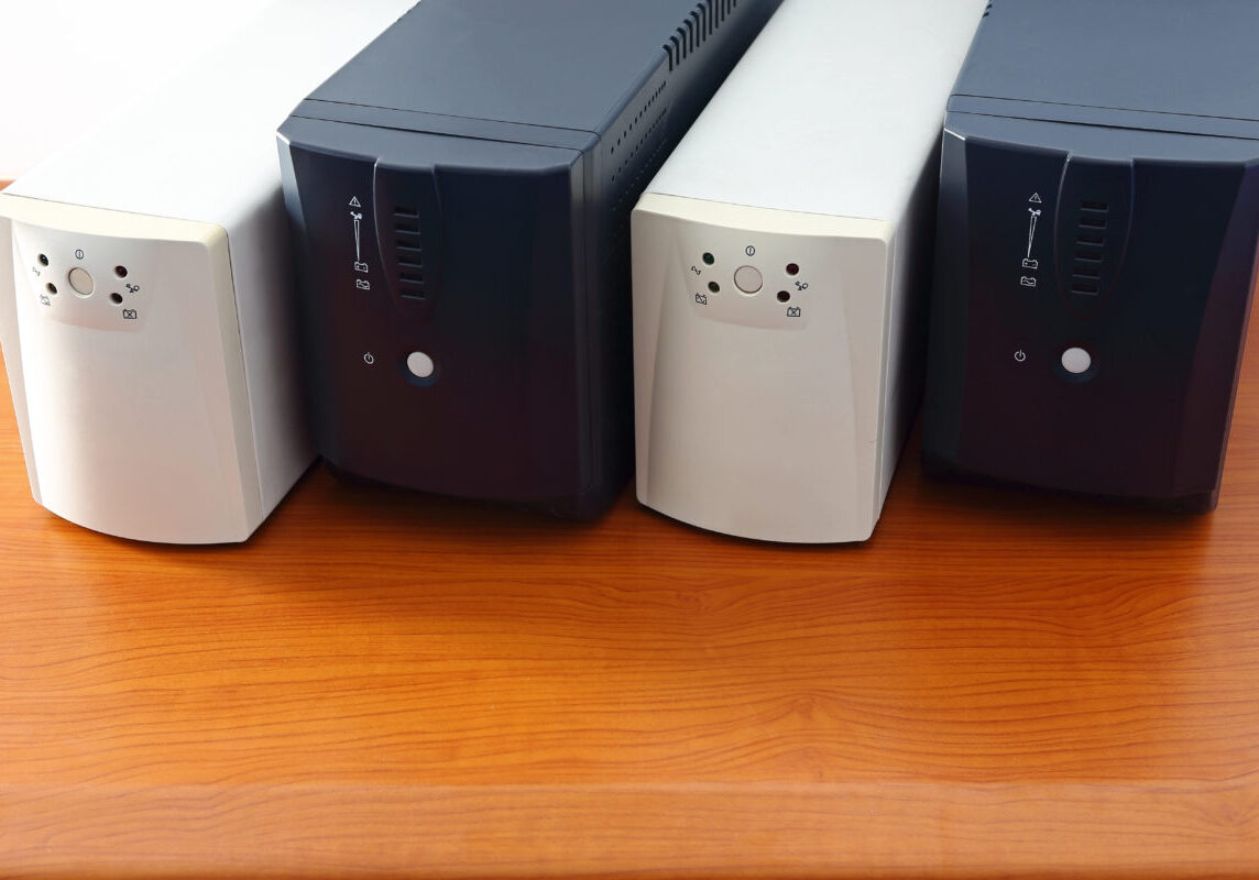 Photo of multiple uninterruptible power supply devices that are white and black.